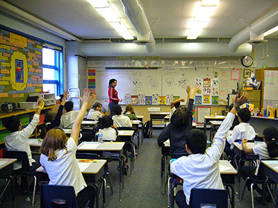 Mei teaching students a how to draw art lesson in a classroom.